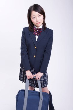 Stüdyoda üniformalı gülümseyen Japon öğrenci portresi.