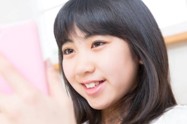 Cep telefonu kullanan küçük kız.