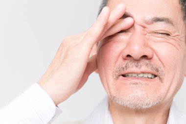 Beyaz arka planda acıdan muzdarip olgun Asyalı adamın portresi.