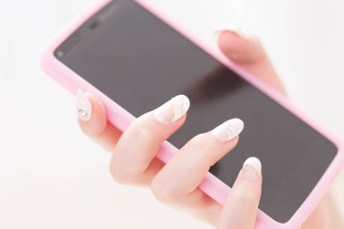 Beyaz arka planda akıllı telefonu tutan kadın.