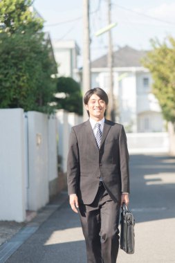 Genç Asyalı işadamı sokakta yürüyor