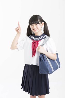 Okul üniformalı güzel bir öğrencinin portresi beyaz arkaplanı işaret ediyor.