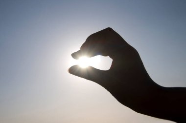 Güneşi tutan kadın silueti 