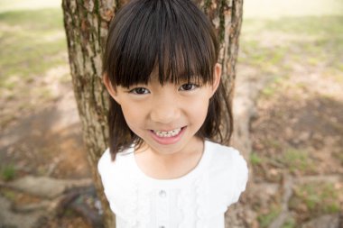 Yaz parkında yürüyen tatlı bir Japon kızı, açık havada eğlenen komik bir çocuğun gündüz portresi.