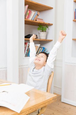 Mutlu Asyalı çocuk ellerini kaldırıyor. 