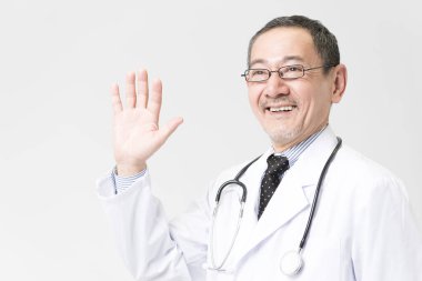 Beyaz önlüklü, olgun Asyalı doktor portresi.