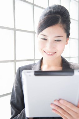 Tablet kullanan genç Asyalı iş kadını