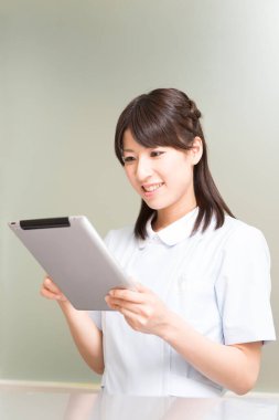 Tablet kullanan Asyalı kadın doktor