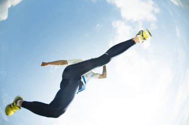 Genç sporcu havada zıplıyor, bulutlu bir arka plan. yüksek kaliteli fotoğraf