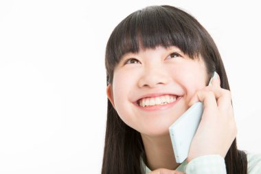 Beyaz arka planda telefonu olan Asyalı genç bir kız izole edilmiş. 