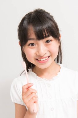 Diş fırçası olan Asyalı bir kız.