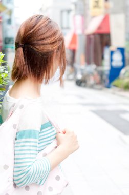 Sokakta çanta taşıyan genç bir kadın.