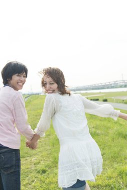 Mutlu genç Asyalı çift yaz parkında koşuyor