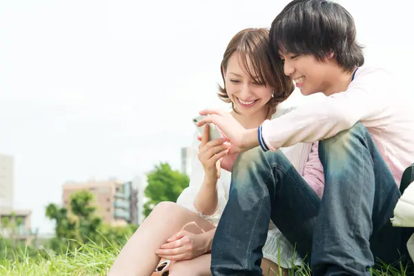 Пара Щасливих Молодих Японських Студентів Які Використовують Смартфон Проводять Час — стокове фото