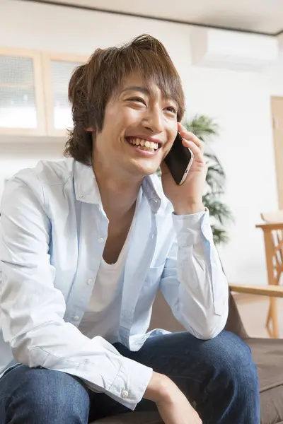 Młody Azjatycki Człowiek Uśmiechnięty Biały Mówić Smartfon — Zdjęcie stockowe