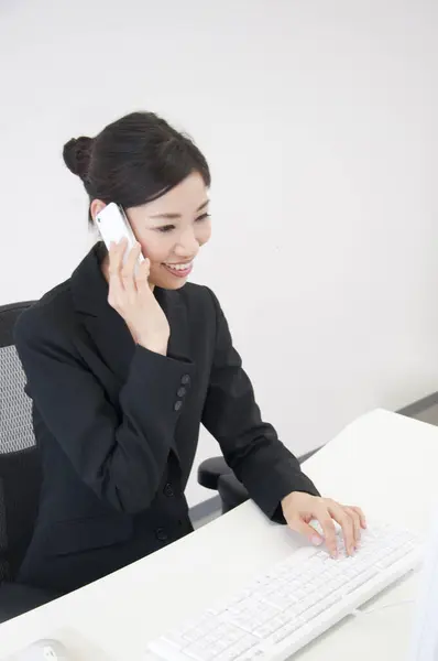 Young Woman Using Computer Talking Smartphone Office Stock Picture