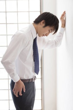 İş adamının düşüncesi, duvarın yanında durmaktan kafası karışıyor. 