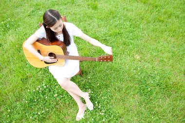 Gitarlı Asyalı genç kadın. 