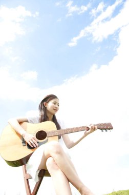 Gitarlı Asyalı genç kadın. 