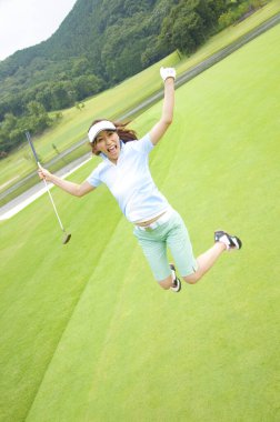 Genç Asyalı golfçü parkurda atlıyor. 