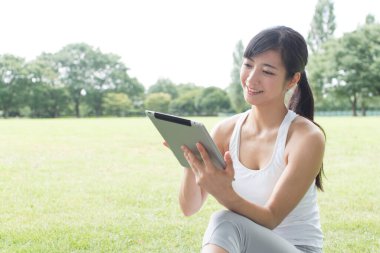 Kadın parkta Tablet PC'yi kullanma 