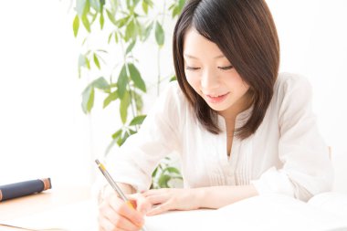 Genç Asyalı kadın bir şeyler yazıyor.