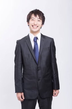 Genç Asyalı iş adamı beyaz gömlek ve kravat takıp gülümsüyor. 