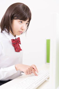 Bilgisayarla çalışan genç bir Japon öğrenci.