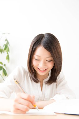 Genç Asyalı kadın bir şeyler yazıyor.