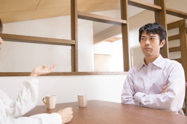 Genç Asyalı çift evde kahve içiyor. 