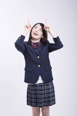 Üniformalı gülümseyen Japon öğrencinin stüdyo portresi.