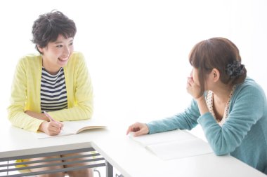 Sınıfta arkadaşıyla konuşan genç bir kadın.