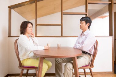 Genç Asyalı çift evde kahve içiyor. 