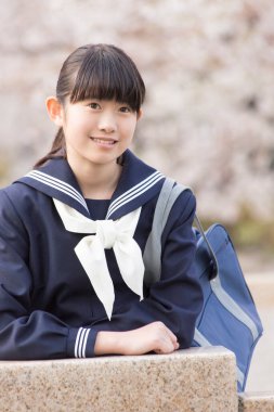 Bahar mevsiminde okul üniformalı güzel Japon öğrencinin portresi.