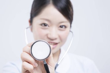 Beyaz üniformalı güzel Asyalı doktorun portresi.