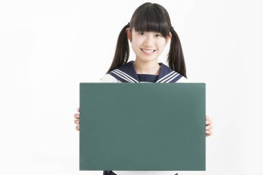 Okul üniformalı güzel genç bir öğrencinin portresi. Elinde yeşil boş bir tahta var.