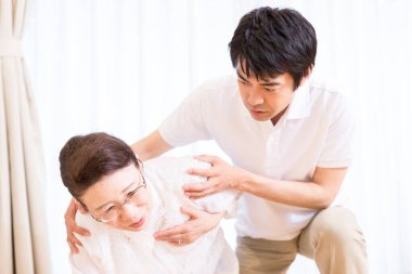 Asyalı son sınıf öğrencisi kadın yere düştü, genç adam kalkmasına yardım ediyordu.