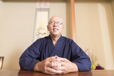 Kimonolu üst düzey bir adamın portresi masada oturuyor. 