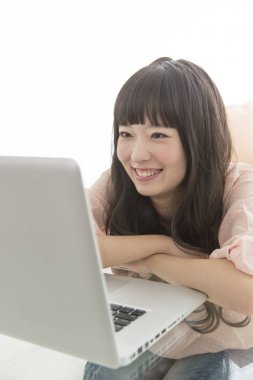 Dizüstü bilgisayarda çalışan genç Asyalı kadın