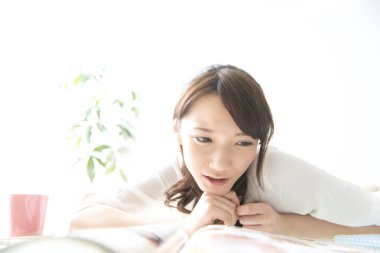 Evde kitabı olan Asyalı bir kadın.