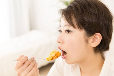 Güzel Japon kadın evde yemek yiyor.