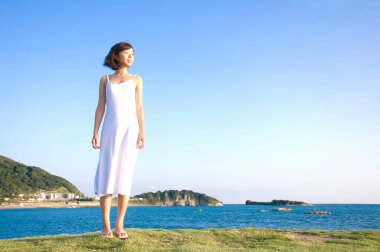 Genç Asyalı kız deniz kıyısında yürüyor. yaz tatili.