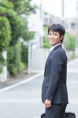 Asyalı işadamı şehirde yürüyor