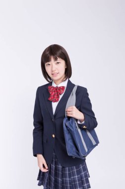 Çantalı gülümseyen Japon öğrencinin stüdyo portresi.