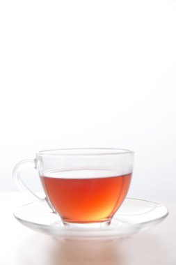 glass cup of tea with saucer on white background.