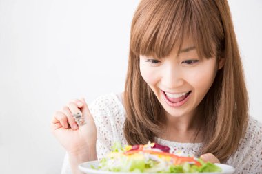 Gülümseyen Japon kadın taze salata tabağıyla