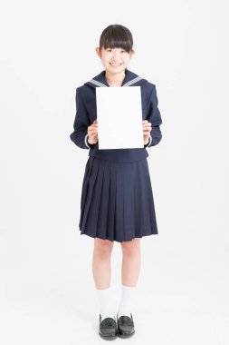 Okul üniformalı güzel bir öğrencinin portresi beyaz arka planda boş bir poster tutuyor.