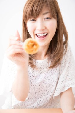 Elinde donut tutan Asyalı kadın.