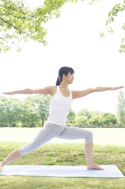 Güzel Japon kadın parkta yoga yapıyor.