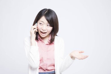 Beyaz arka planda telefonu olan genç Asyalı bir kadın.